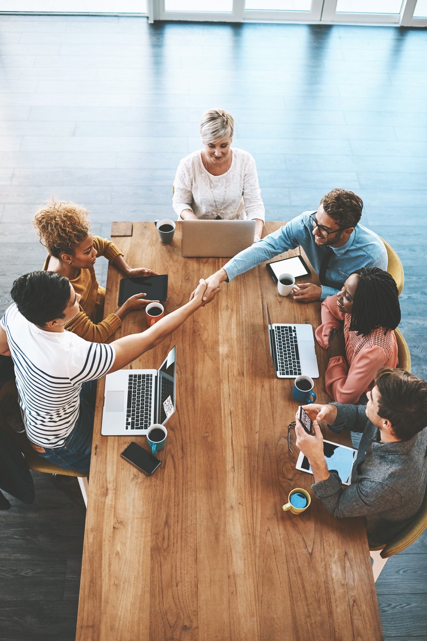 Charity colleagues shaking hands during a meeting in a modern office