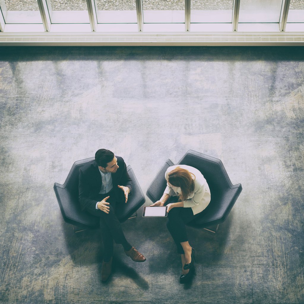 Overhead view of two business persons in the lobby advisory for workplace giving
