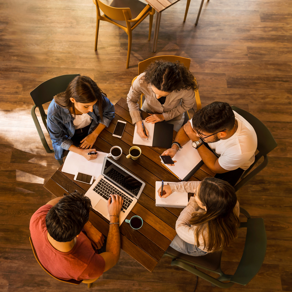 Group of people working around a table for workplace giving